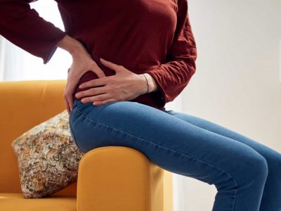 Woman with strong hip pain at home.